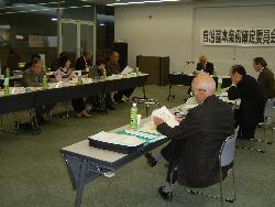 2列に並べられた長机と椅子に座っている参加者と司会進行役の男性の様子の写真その5