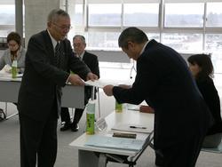 スーツ姿の男性から委嘱状を受け取る男性の写真