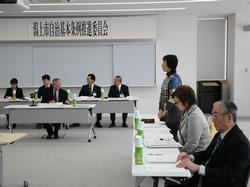 大勢の前で起立し、話している女性の写真
