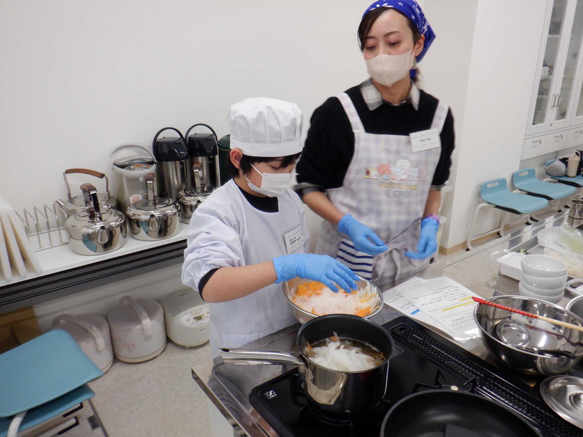 鍋に野菜をいれるところ