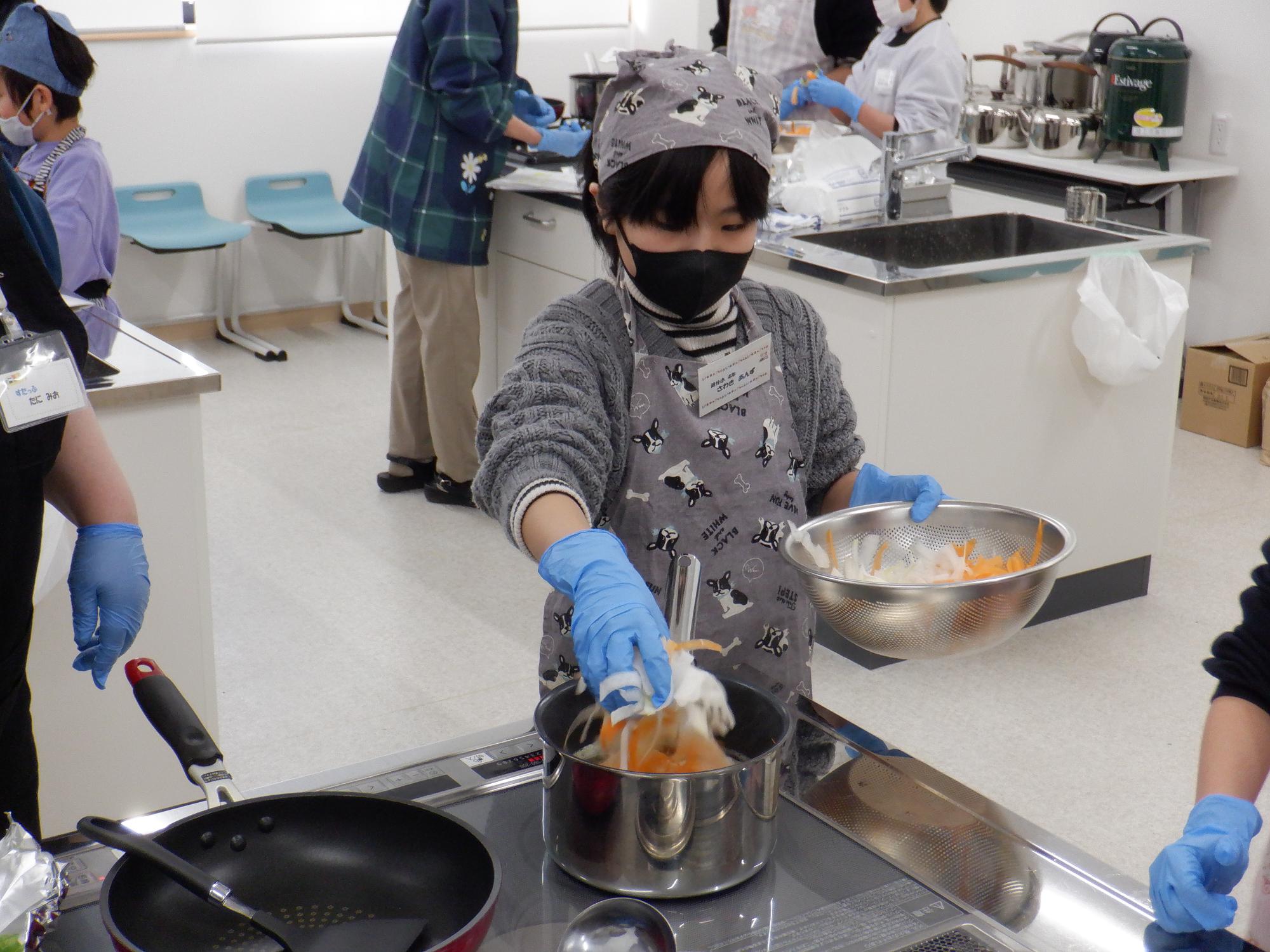 鍋に野菜をいれるところ