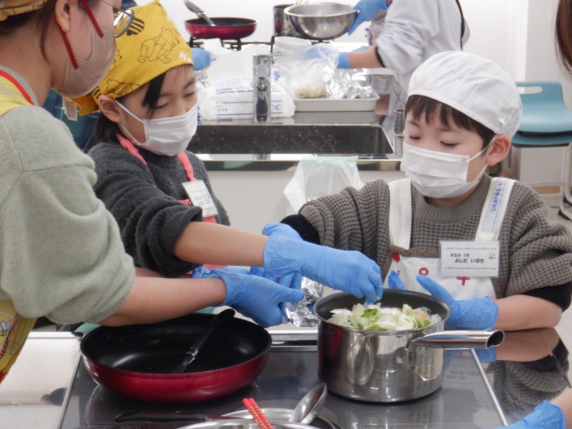 鍋に野菜をいれるところ