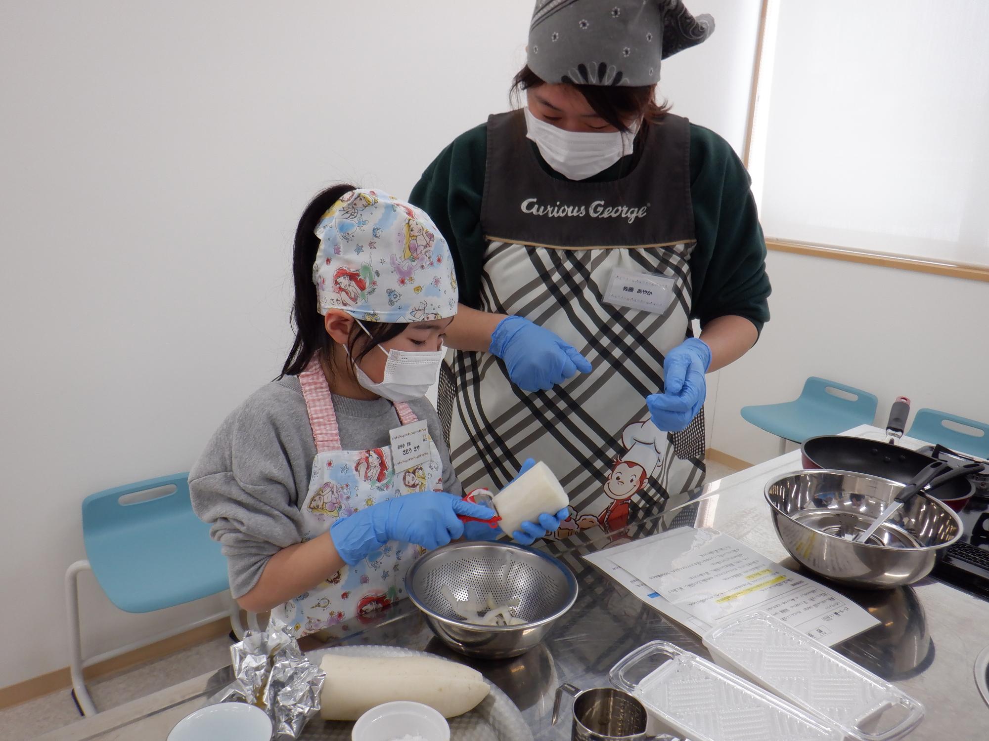 ピーラーで大根をそぎ切りにしているところ