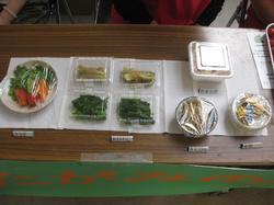 透明な容器や器に盛られた色々な野菜が展示されている写真